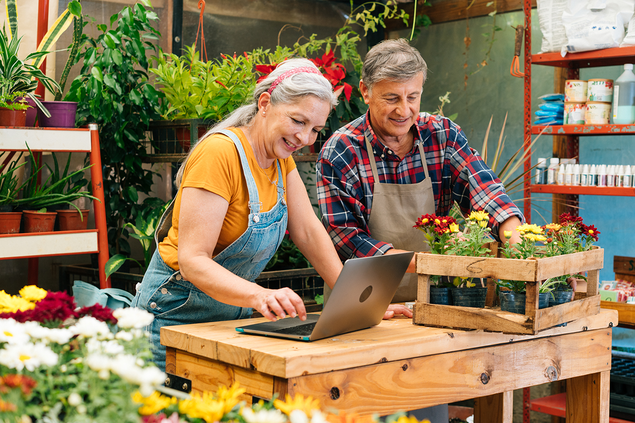 Senior couple work together filling online orders in plant nursery